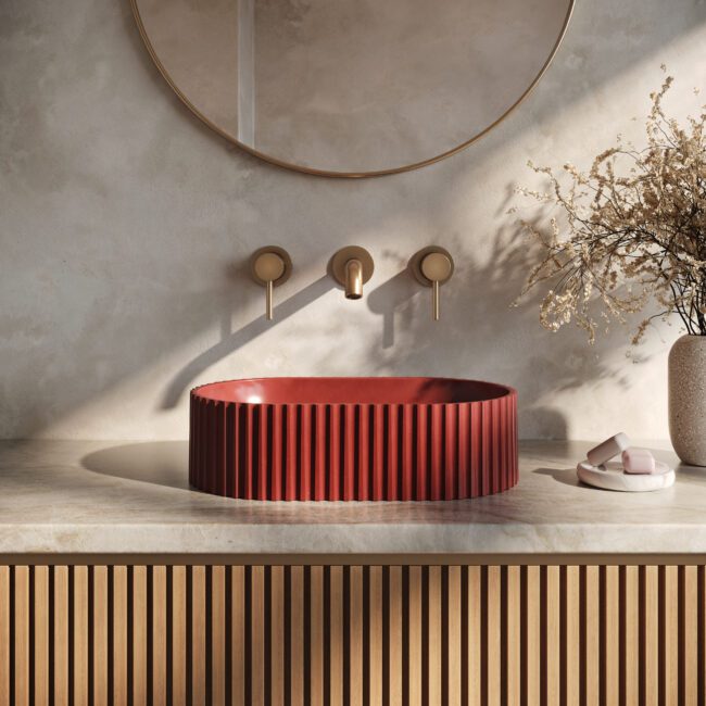 Geni red concrete vessel sink by Crete Collective, fluted pill-shaped bathroom sink