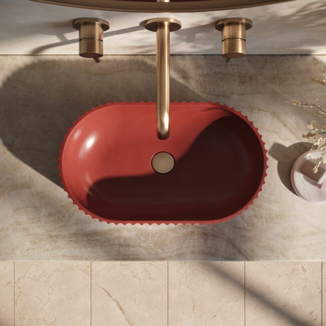 Geni red concrete vessel sink by Crete Collective, fluted pill-shaped bathroom sink