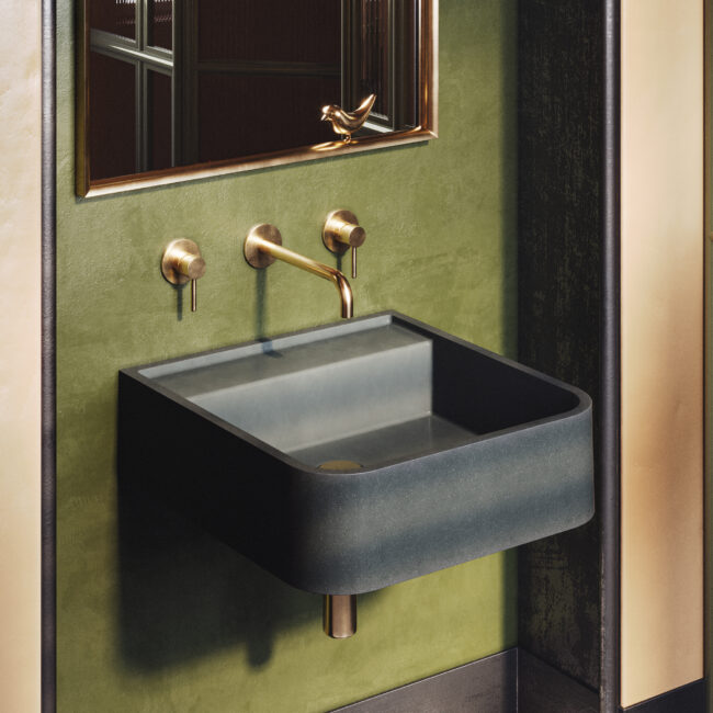 Iris concrete sink in a modern bathroom, wall-mounted with brass fixtures. ADA-compliant and perfect for both accessible and luxury interiors.